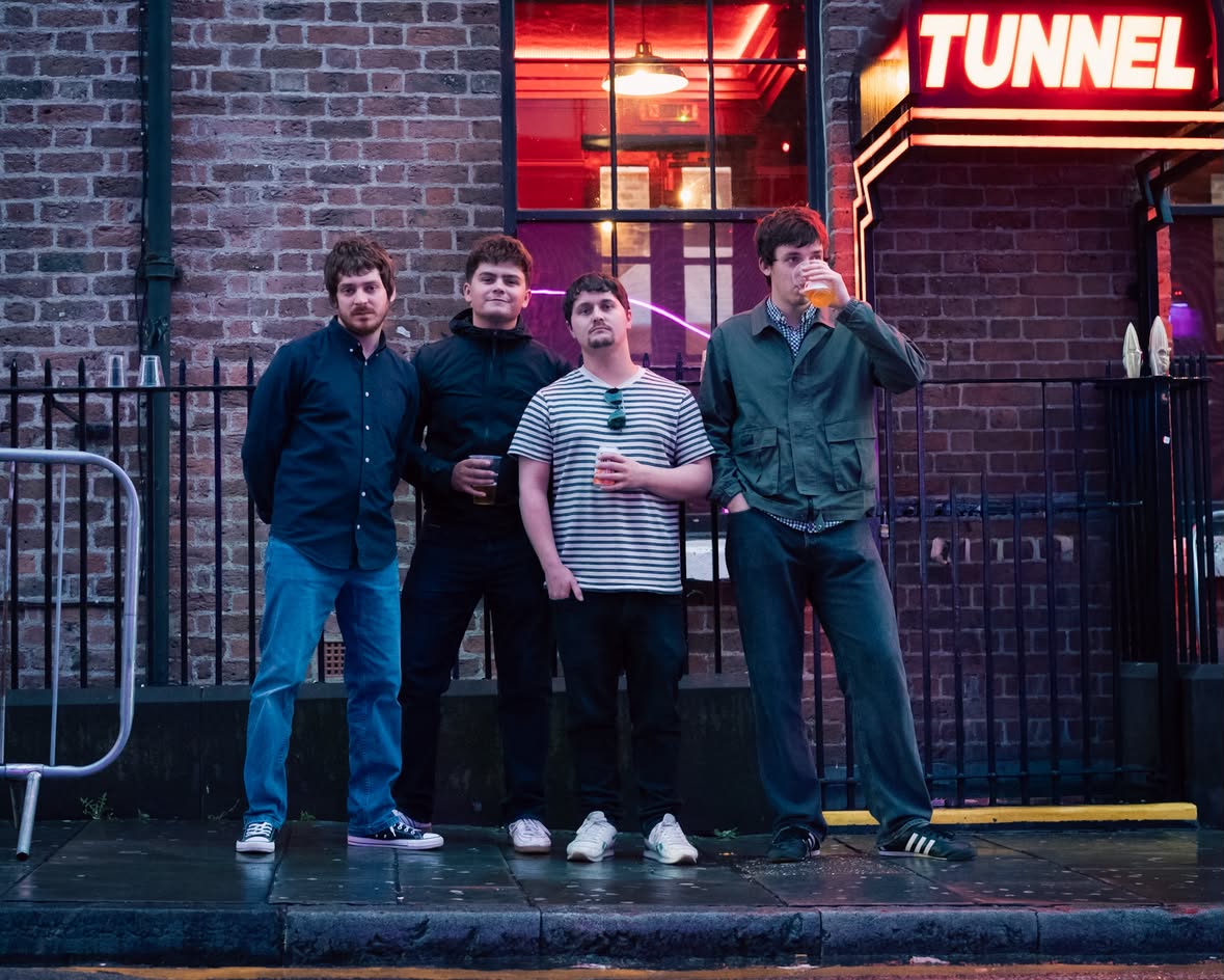 Indie Rock Band Headwired Stood Outside In Front of a Neon Sign