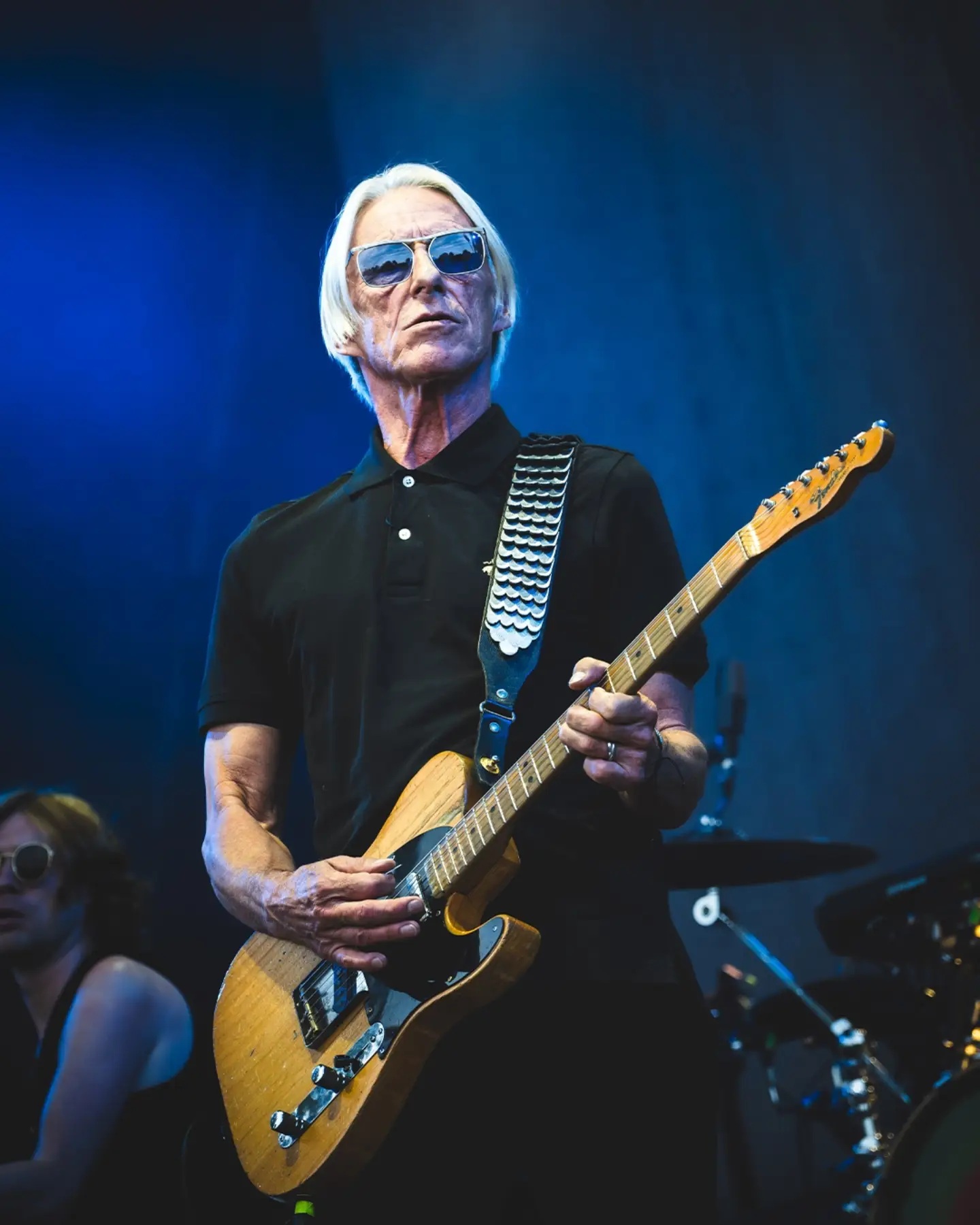 Paul Weller performing live with his guitar on stage