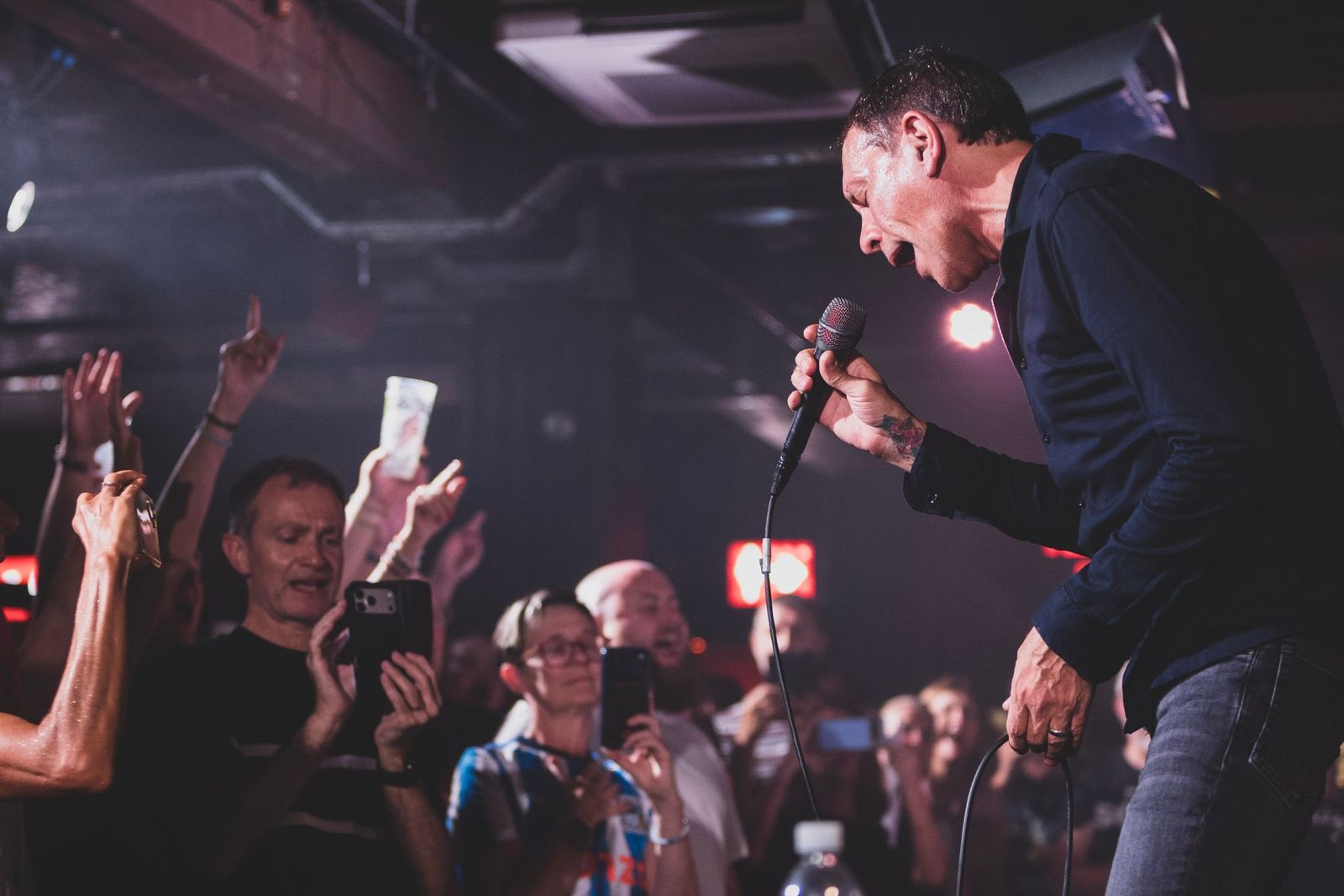 Shed Seven's Rick Witter singing down the microphone during an acoustic set at London's 100 Club